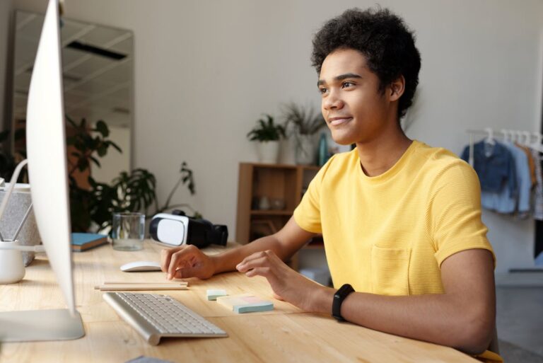 Personne âgée souriante devant un ordinateur portable